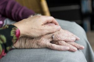 A person holding their hands over another persons hand.