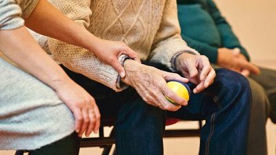 A person holding an apple and another hand